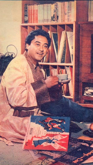 穿長袍的男人坐在地板上，周圍有唱片和書籍 — 凱羅·忍 壁紙