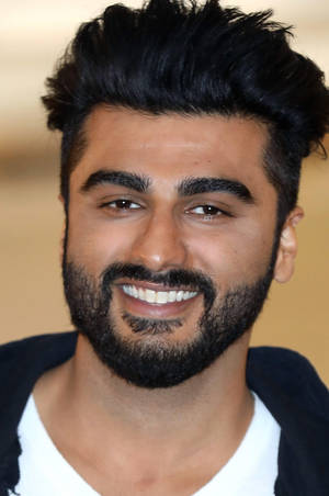 一個微笑的黑髮鬍鬚男士穿著白襯衫和黑色外套。 — 阿盧·阿瓊 壁紙