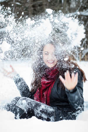 女人在雪中大笑，雪花在她周圍飛舞，身處冬季森林。 — 冬季風景 壁紙