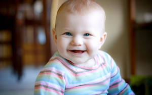 一個快樂的嬰兒，藍眼睛，穿著條紋襯衫在室內。 — 嬰兒男孩 壁紙
