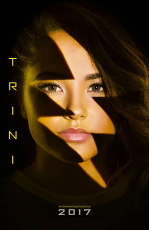 金色光線照亮女性臉龐，帶有銳利幾何陰影，文字顯示 Trini。