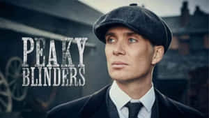 戴平頂帽、穿西裝的男人在Peaky Blinders宣傳圖片中看向鏡頭外。