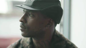 戴帽男人望向窗外，頸部刺青可見 — Skepta 壁紙