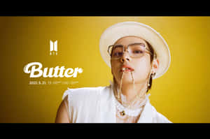 BTS成員戴白色帽子和眼鏡，在黃色背景前，附有Butter發行資訊。 — MacBook Pro M2 壁紙