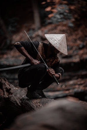 戴圓錐形帽子的人蹲在黃昏的森林中持劍。 — 混沌武士 壁紙