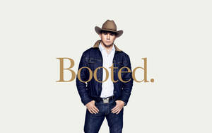 戴著牛仔帽和牛仔外套的男人雙手叉腰站在「Booted.」字樣旁 — 傑森·塔圖姆 壁紙