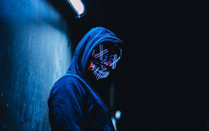 夜晚在黑暗小巷中戴著發光骷髏面具的連帽衫人物。 — 駭客面具 壁紙
