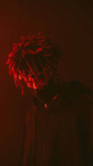 在紅色燈光下，戴著眼鏡、梳著辮子的人穿著連帽衫。 — Scarlxrd 壁紙