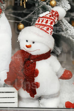 戴紅色圍巾和帽子的雪人，在白雪皚皚的節日櫥窗展示中 — 2:3 壁紙