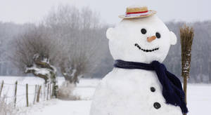 戴草帽和藍色圍巾的雪人在雪地上拿著掃帚。 — 白雪公主 壁紙