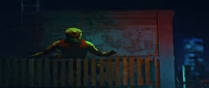一個戴著面具的超級英雄在霓虹燈籠罩的城市夜晚蹲在柵欄後面。 — 漫威復仇者聯盟 壁紙