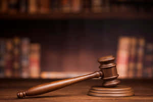 法庭場景中支架上的木槌，背後有書架。 — 美國正義協會 壁紙