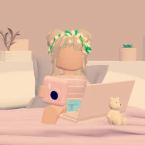 擁有花卉頭髮的Roblox虛擬角色在床上使用粉紅色相機和筆記型電腦，與泰迪熊一起。 — 美學 Roblox 壁紙