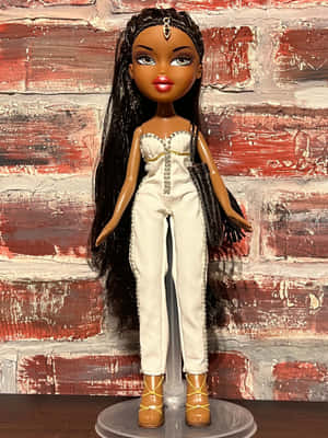 Bratz 公仔穿著白色連身褲和棕色靴子，背景為紅磚牆。 — 2048x2732 壁紙