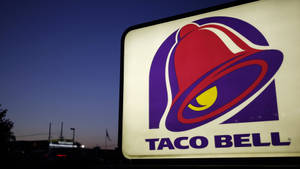 暮色中發光的Taco Bell招牌，背景有麥當勞。 — 塔可 壁紙