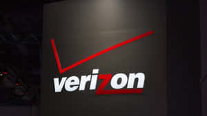 Verizon標誌在深色牆壁上以紅色和白色照明。 — 威訊 壁紙