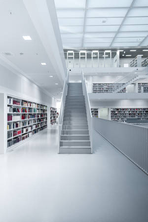 一個現代白色圖書館，設有書架和中央樓梯。 — 小米平板 8 Pro 壁紙