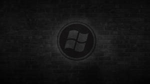 深色磚牆上聚光燈下的Windows標誌 — 簡約暗黑美學 壁紙