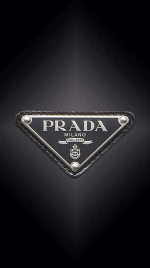 深色背景上的Prada標誌徽章，帶有金屬和皮革細節。 — 普拉巴斯 壁紙