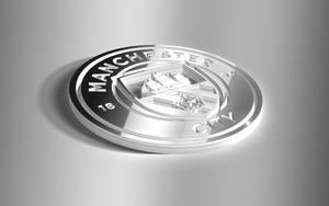 灰色背景上閃亮的銀色曼徹斯特城足球俱樂部徽章