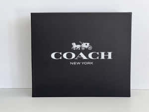白色表面上的黑色 Coach New York 品牌盒子。 — 教練 壁紙
