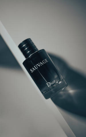 黑色 Dior Sauvage 香水瓶在白色表面上，帶有柔和陰影。 — Galaxy Tab S10+ 壁紙