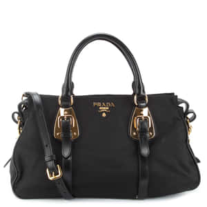 黑色Prada手提包，配以金色金屬配件和皮革肩帶。