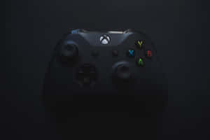 黑色Xbox控制器，在深色背景上有彩色按鈕。 — 高畫質遊戲 壁紙