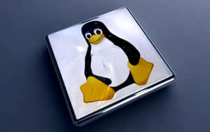 Linux企鵝吉祥物在一個閃亮的方形按鈕上，背景為深灰色表面。 — 企鵝 GIF 壁紙