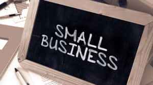 黑板，上面用白色粉筆寫著small business，放在有辦公用品的桌子上。 — 商業 壁紙