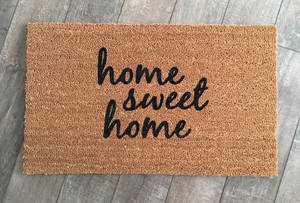 灰色木地板上帶有 home sweet home 文字的椰殼纖維門墊 — 甜蜜的家 壁紙
