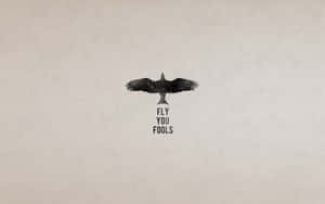 烏鴉剪影與文字 fly you fools 在米色紋理背景上。 — 哈利波特學院 壁紙