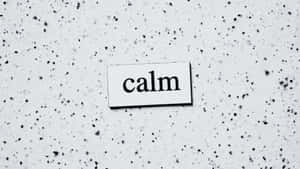 一個白色標牌，上面有單詞 calm，背景為帶斑點的灰色。 — 字體排印 壁紙