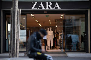 模糊的人坐在Zara服裝店外面，店內可見人體模型。 — 洋裝 壁紙