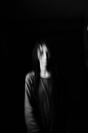 一個模糊的幽靈般長髮人物在黑暗的房間裡。 — 暗黑少女風 壁紙
