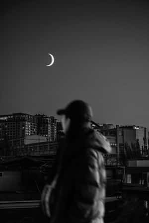 一個人在新月下夜晚走過城市建築的剪影。 — 暗黑少女風 壁紙