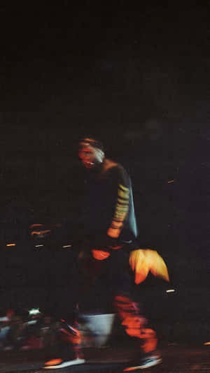 一個人在夜間行走，帶有動態模糊和彩色光條。 — ASAP Rocky 壁紙