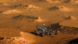 一個機械探測車穿越火星佈滿灰塵的橙色地形，背景是岩石丘陵。 — 火星 壁紙