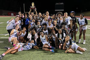 高中美式足球隊在夜間球場上手持獎盃慶祝勝利。 — 運動 壁紙