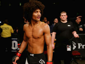 一個赤裸上身、捲髮的MMA拳手在比賽後站在八角籠內。 — 終極格鬥冠軍賽 壁紙