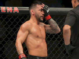 一個有刺青的男性MMA拳手在UFC八角籠內擦拭汗水。 — 極限運動 壁紙