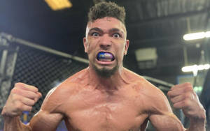 肌肉發達鬥士在MMA籠內握緊拳頭咆哮。 — 極限運動 壁紙