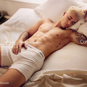 金髮刺青男人穿著白色Calvin Klein內褲在床上睡覺。 — 卡文克萊 壁紙