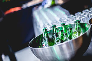 酒吧中疊起的玻璃杯旁金屬碗內的冰涼海尼根啤酒瓶。 — 啤酒 壁紙