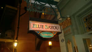 Blue Bayou Restaurant招牌在夜間發光，帶有華麗金色裝飾和燈籠。 — 海洋藍 壁紙