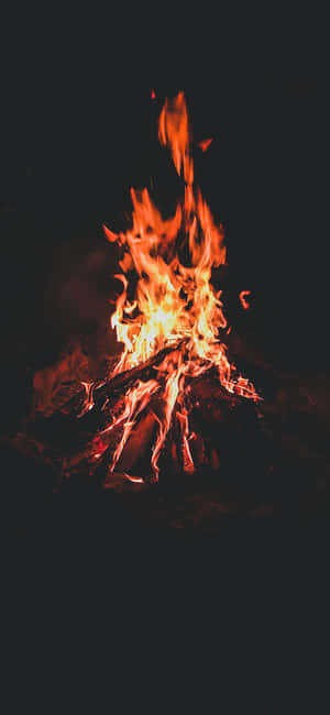 一個充滿活力的營火，在黑暗的夜晚燃燒著橙色和黃色的火焰。 — Galaxy A07 壁紙