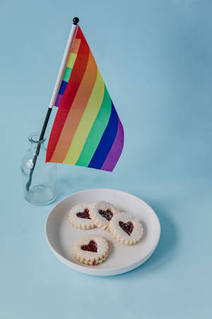 玻璃瓶內的彩虹旗，旁邊放著一碟心形果醬餅乾。