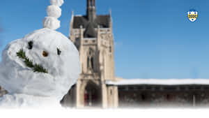 冬日裡，積雪的大教堂前，一個樹枝臉的雪人。 — 可愛的雪 壁紙