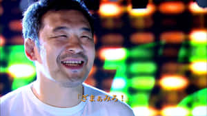 男人在夜晚背後有明亮的霓虹燈光下大笑。 — 櫻島麻衣 壁紙
