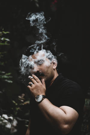 男人在黑暗森林中吸煙，煙霧在他臉龐周圍旋轉。 — 抽菸 壁紙